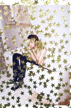 a woman sitting on top of a toilet surrounded by stars