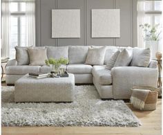 a living room scene with focus on the sectional sofa and footstool in the center