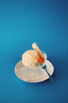 an ice cream sundae on a white plate with a spoon and orange peel in it