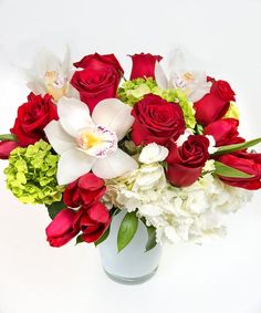 a vase filled with lots of red and white flowers