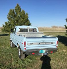 a blue pick up truck parked in the grass