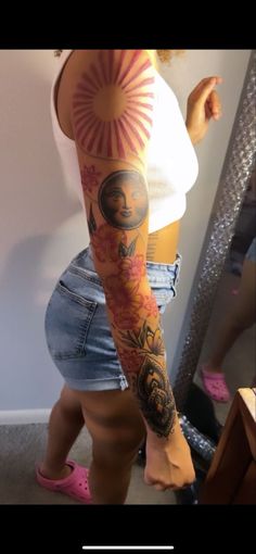 a woman with tattoos on her arm and leg is standing in front of a mirror