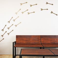 an arrow wall decal on the side of a white wall next to a wooden bench