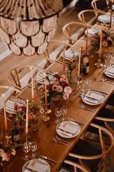 the table is set with candles, plates and glasses for dinner guests to eat at