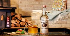 a bottle of alcohol sitting on top of a tray next to a glass filled with liquid