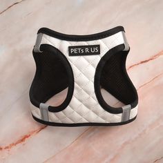 a white and black dog harness with the words petrus on it's chest