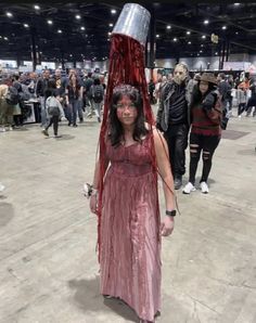 a woman in a red dress with a bucket on her head