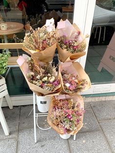 a bunch of dried flowers sitting on top of a white table next to a window