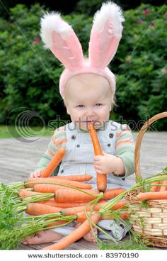 a baby with bunny ears holding carrots in front of an instagram post on twitter