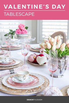 the table is set with pink and white flowers in vases, plates, silverware, and napkins