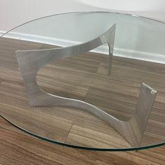 a glass and metal coffee table on wooden floor