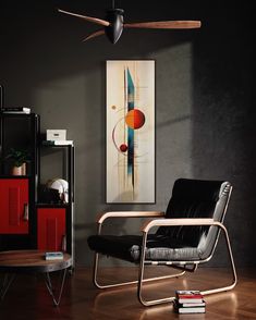 a living room with a black chair and a painting on the wall next to it