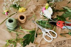 some flowers and scissors are laying on the table next to it's spools