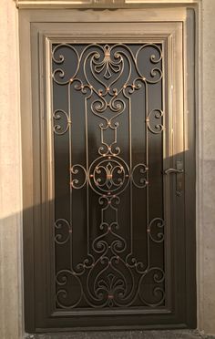 an ornate iron door on the side of a building