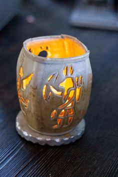 a lit candle holder sitting on top of a wooden table