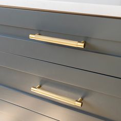 a close up view of some drawers with handles on each drawer and the bottom one is gold