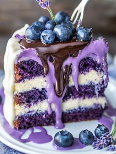 a piece of cake with blueberries on top and chocolate drizzled over it