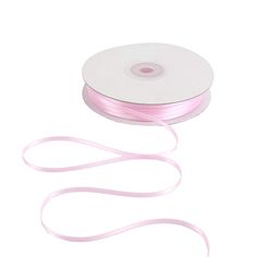 a roll of pink satin ribbon on a white background