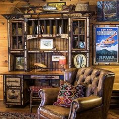 a leather chair sitting in front of a wooden book shelf filled with books and other items