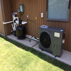 an air conditioner sitting on the side of a building next to a dryer