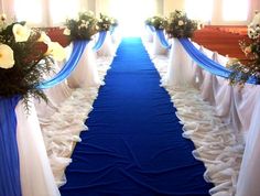 a blue and white wedding aisle with flowers on the top, along with draping