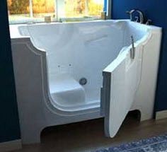 a bathtub sitting next to a window in a room with blue walls and wooden floors