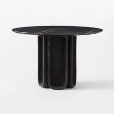 a round table with three black columns on it's sides and one column in the middle