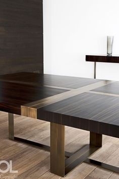 a wooden table sitting on top of a hard wood floor next to a white wall