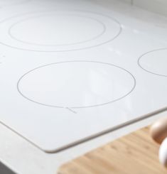 a white stove top sitting on top of a wooden counter