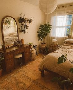 a bedroom with a bed, dresser and mirror on the wall next to potted plants