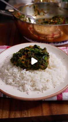 a white plate topped with rice and broccoli on top of a wooden table