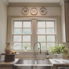 a kitchen sink sitting under a window next to a faucet and dishwasher