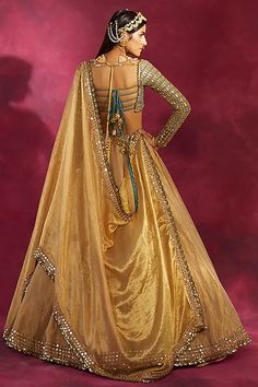 a woman in a gold gown with an open back