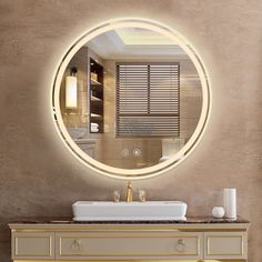 a bathroom with a round mirror above the sink and gold accents on the countertop