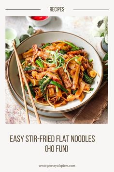 a bowl filled with noodles and vegetables next to chopsticks on top of a table