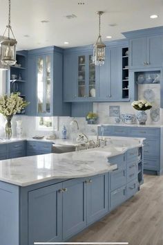 a large kitchen with blue cabinets and white counter tops, along with an island in the middle