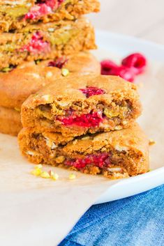 two pieces of cake sitting on top of a white plate next to raspberries