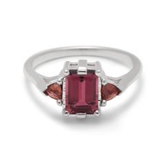 A three stone engagement ring with an emerald cut and emerald shape 7x5mm pink tourmaline center stone with two garnet trillion side stones set in sterling silver. The Subtle Knife, Three Stone Ring, Three Stone Rings, Rutilated Quartz, Quartz Stone, Three Stone, Pink Tourmaline, Stone Settings, Stone Ring