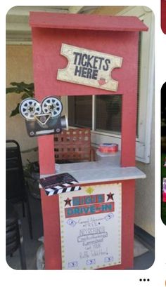 a ticket kiosk is set up in the shape of a drive - in movie theater