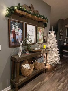 a christmas tree is in the corner of a room with two pictures on the wall