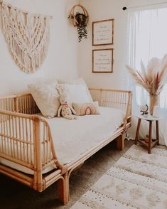 a baby's room with a crib, rugs and pictures on the wall