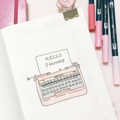 a notebook with a drawing of an old fashioned typewriter on it and some markers