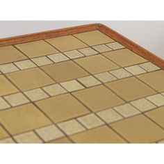 a close up of a tile floor with brown and tan tiles on the bottom half