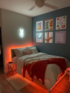 a bed sitting in a bedroom next to a wall with pictures hanging on it's side