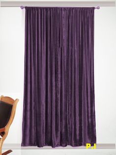 a chair sitting in front of a purple curtain