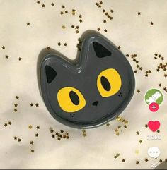 a black and yellow cat brooch with stars around it