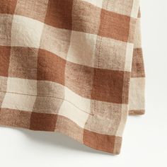 a brown and white checkered blanket laying on top of a table