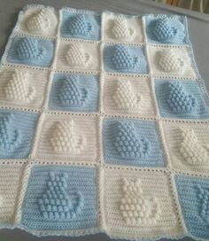 a crocheted blanket with blue and white squares