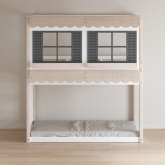 a white bunk bed with two windows on the top and bottom shelf, in front of a wall