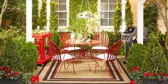 an outdoor dining area with red chairs, table and potted plants on the patio